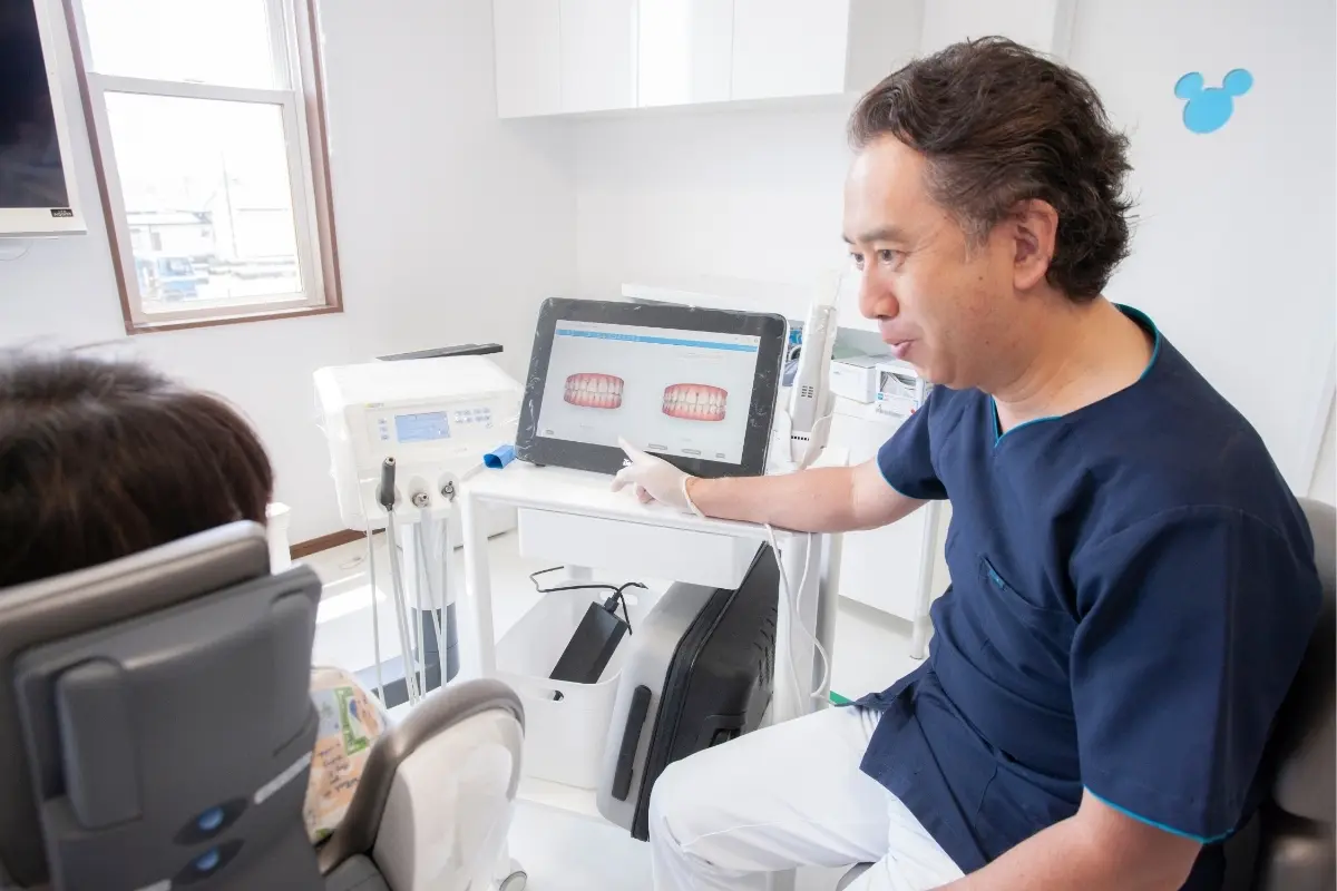 モニターの口腔内画像を指さしながら説明をする中央歯科クリニックの院長