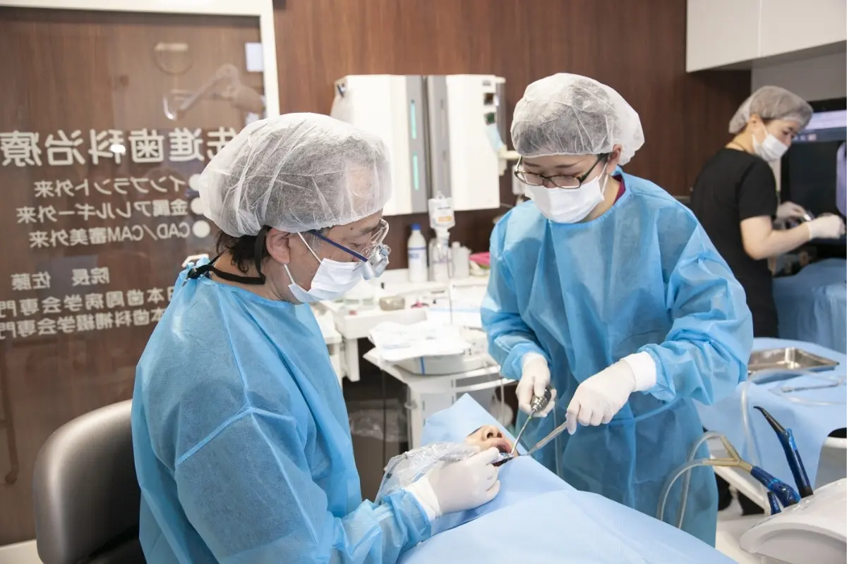 中央歯科クリニック院長が手術着を着用して治療する様子
